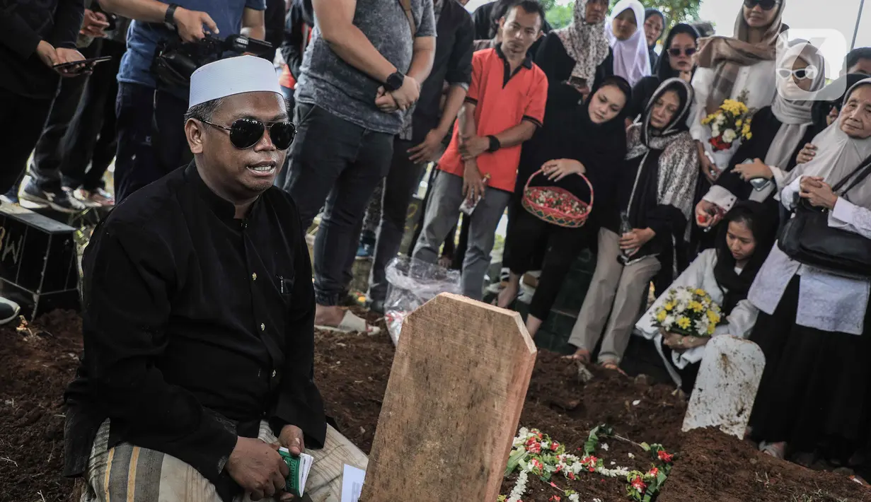 Seorang pria membacakan doa saat pemakaman mantan artis cilik Cecep Reza di TPU Layur Penggilingan, Jakarta, Rabu (20/11/2019). Cecep Reza meninggal pada usia 31 tahun karena penyakit jantung. (Liputan6.com/Faizal Fanani)