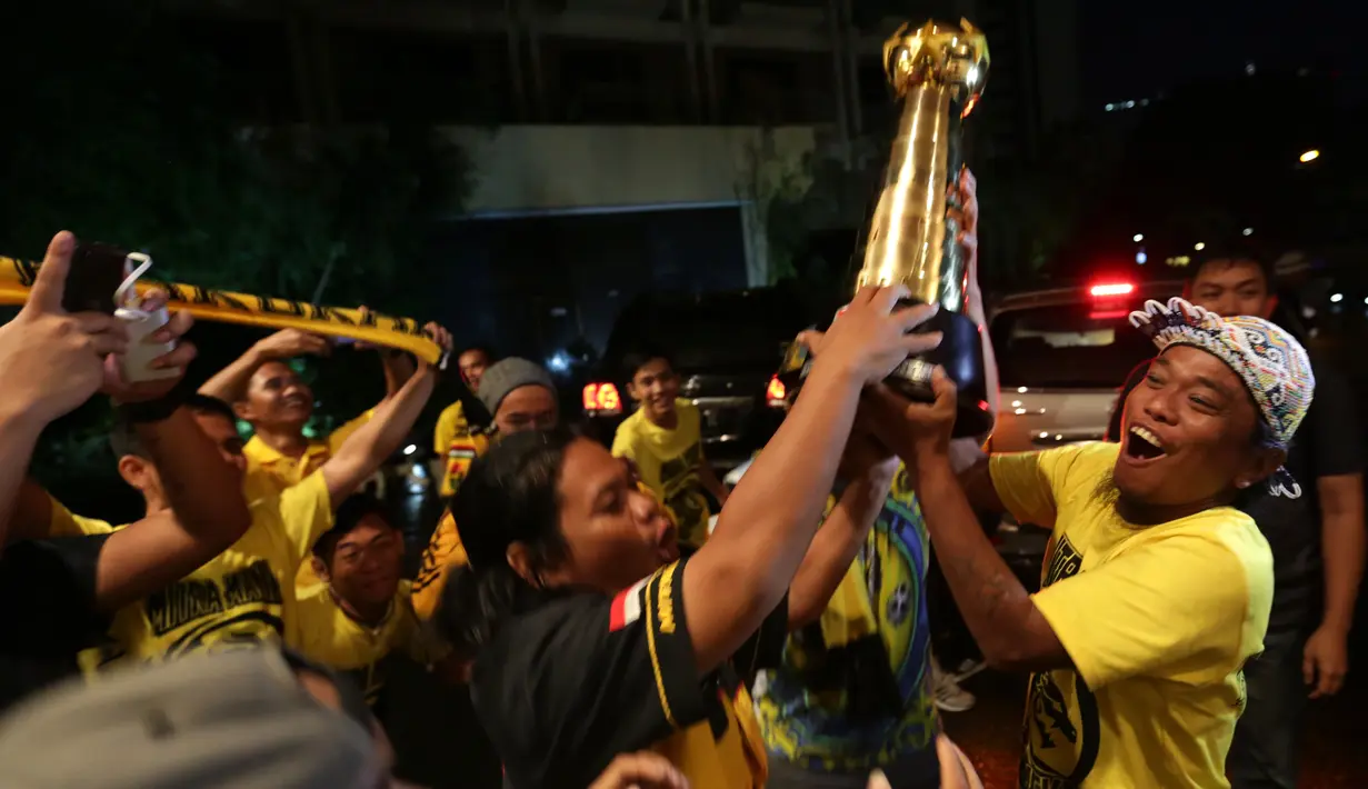 Suporter Mitra Kukar merayakan gelar juara dengan trofi Piala Jenderal Sudirman di Hotel Sultan, Jakarta, Minggu (24/1/2016). (Bola.com/Arief Bagus)