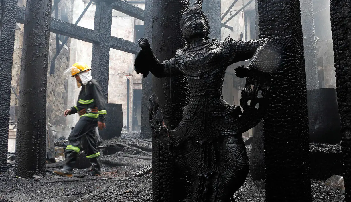 Seorang petugas berjalan di sebuah bangunan yang terbakar di Hotel Istana Kandawgyi di Yangon, Myanmar (19/10). Api telah melahap hotel bintang lima yang sering dikunjungi wisatawan asing di kota Yangon, Myanmar. (AP Photo/Thein Zaw)