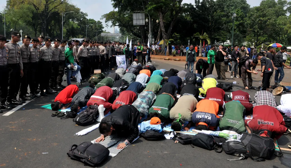 Mahasiswa melaksanakan salat berjamaah disela aksi unjuk rasa di depan Istana Negara, Jakarta, Kamis (21/5/2015).  Aksi tersebut menuntut agar Pemerintahan memprioritaskam masyarakat pribumi daripada asing. (Liputan6.com/Johan Tallo)