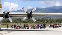 Warga Palu bersiap masuk ke pesawat Hercules TNI AU tujuan Makasar-Malang di Bandara Mutiara Sis Al-Jufri Palu, Sabtu (6/10). Pesawat Hercules yang membawa warga Palu terbang tiga kali dalam sehari. (Liputan6.com/Fery Pradolo)