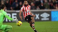 Striker Brentford, Bryan Mbeumo mencetak gol ke gawang Liverpool yang dijaga Alisson Becker pada laga Liga Inggris 2022/2023 di Gtech Community Stadium, London (2/1/2023). Bryan Mbeumo tampil di Liga Inggris bersama Brentford yang telah diperkuatnya sejak awal musim 2019/2020. Ia ikut membawa Brentford promosi ke Premier League pada awal musim 2021/2022. Hingga kini ia telah tampil dalam 73 laga di Premier League dengan torehan 13 gol dan 15 assist. (AFP/Adrian Dennis)