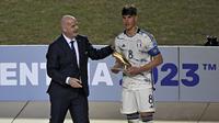 Presiden FIFA, Gianni Infantino (kiri) menyerahkan trofi Golden Boot Award kepada gelandang Italia, Cesare Casadei setelah laga final Piala Dunia U-20 2023 antara Uruguay menghadapi Italia di Unico Diego Armando Maradona Stadium, La Plata, Argentina, Senin (12/6/2023) dini hari WIB. Cesare Casadei dinobatkan sebagai top skor turnamen dengan total mencetak 7 gol. (AFP/Luis Robayo)