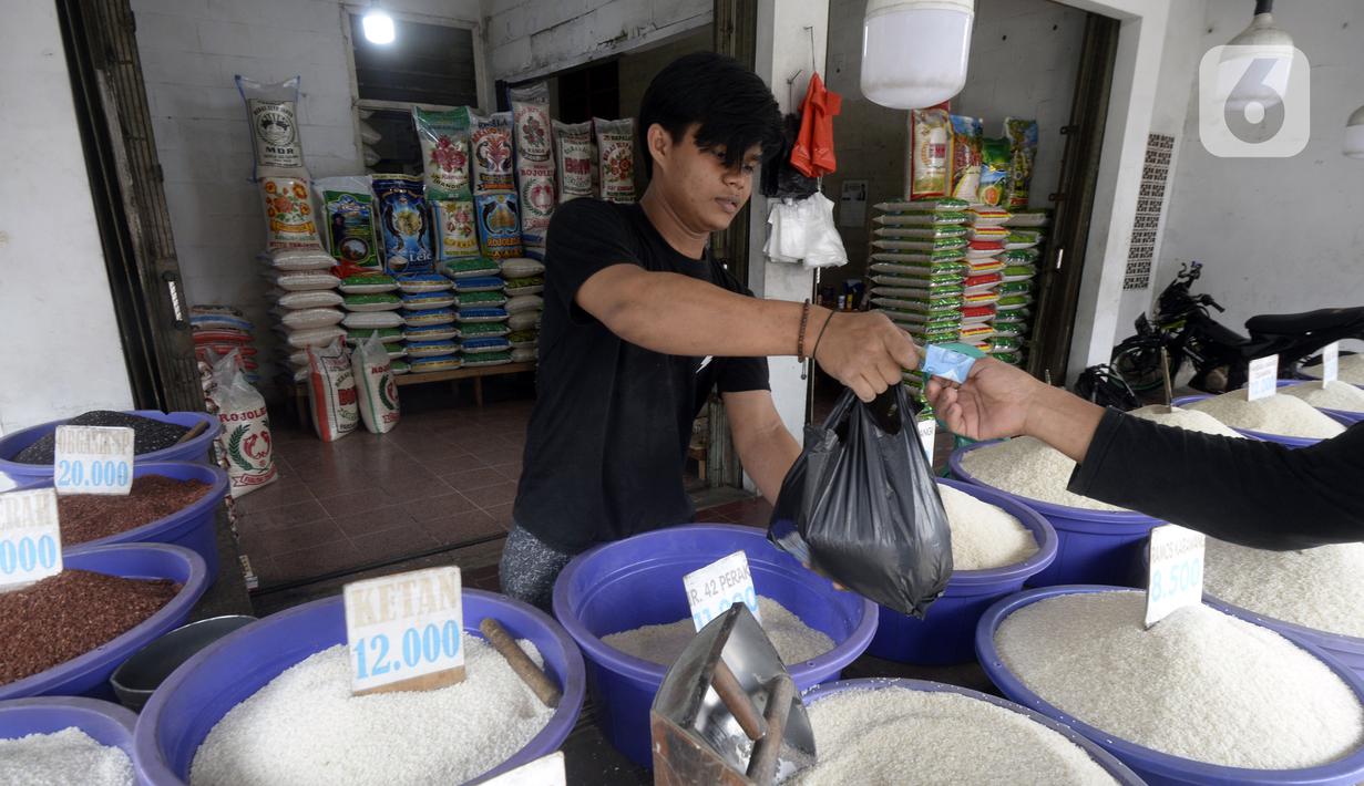 Pedagang beras bertransaksi dengan pembeli di pinggir Jalan Raya Pamulang, Tangerang Selatan, Banten, Jumat (11/12/2020). Jelang Natal dan Tahun Baru 2021, harga beras dipasaran masih normal tidak ada kenaikan. (merdeka.com/Dwi Narwoko)
