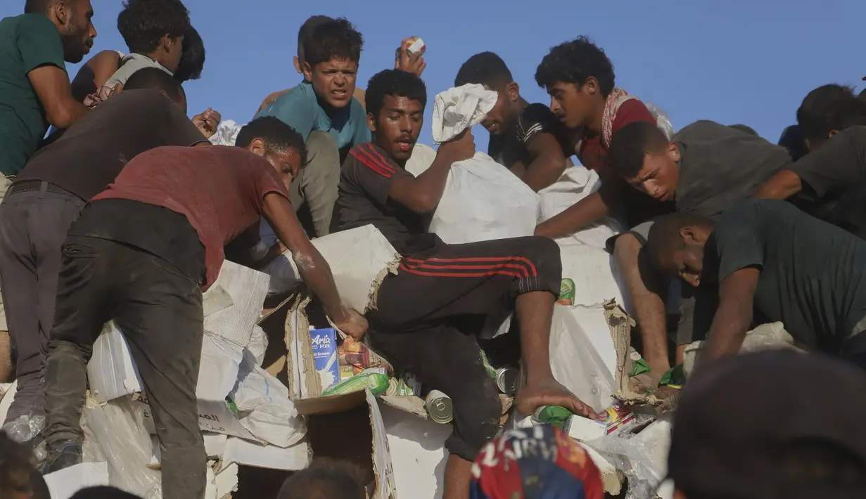 Mereka menaiki truk terbuka untuk membawa pulang paket bantuan yang terbatas jumlahnya. (AP Photo/Mariam Dagga)