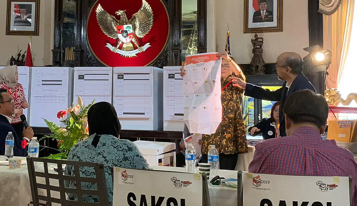 Petugas KPPS Luar Negeri bersama pengawas dan saksi melakukan penghitungan surat suara Pemilu 2019 yang dikirimkan melalui pos maupun yang dicoblos langsung di TPS, di KBRI Washington DC, Kamis (18/4). Jokowi meraih 1113, sementara pasangan Prabowo-Sandi meraih 352 suara. (Liputan6.com/HO/Butet)