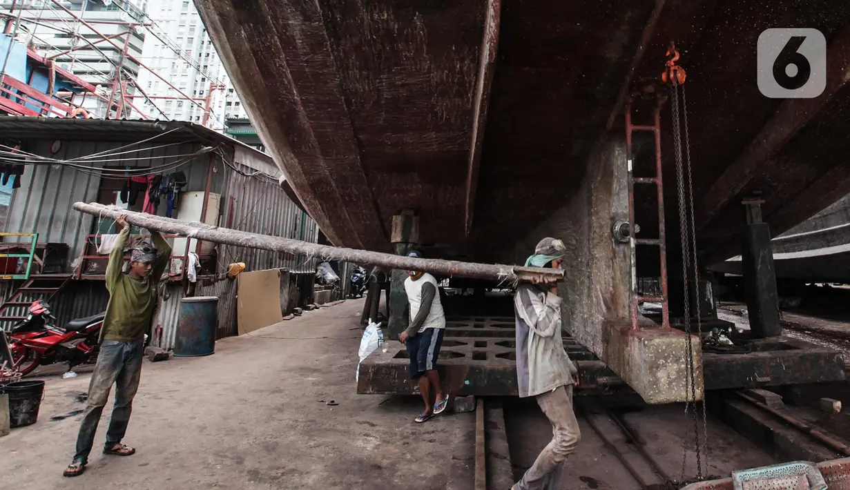 Buruh melakukan perbaikan kapal nelayan di Galangan kapal, Muara Angke, Jakarta, Minggu (23/12/2020). Dimasa pandemi Covid 19 aktivitas di galangan kapal tetap berjalan normal seperti biasa. (Liputan6.com/Angga Yuniar)