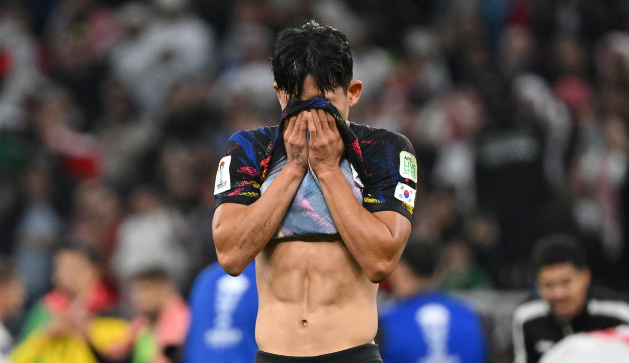 Pemain Korea Selatan, Jeong Woo-yeong menutup mukanya setelah kalah dari Yordania pada laga semifinal Piala Asia 2023 di Ahmad Bin Ali Stadium, Doha, Qatar, Selasa (06/02/2024). Korea Selatan kalah dengan skor 0-2. (AFP/Hector Retamal)