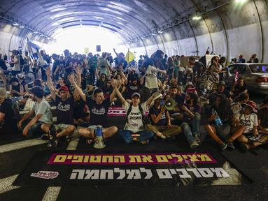 Keluarga dan pendukung warga Israel yang disandera oleh militan Hamas di Gaza sejak serangan pada 7 Oktober 2023, meneriakkan slogan-slogan saat mereka memblokir arus lalu lintas di sebuah terowongan di Yerusalem pada 17 Agustus 2025. (Menahem Kahana/AFP)