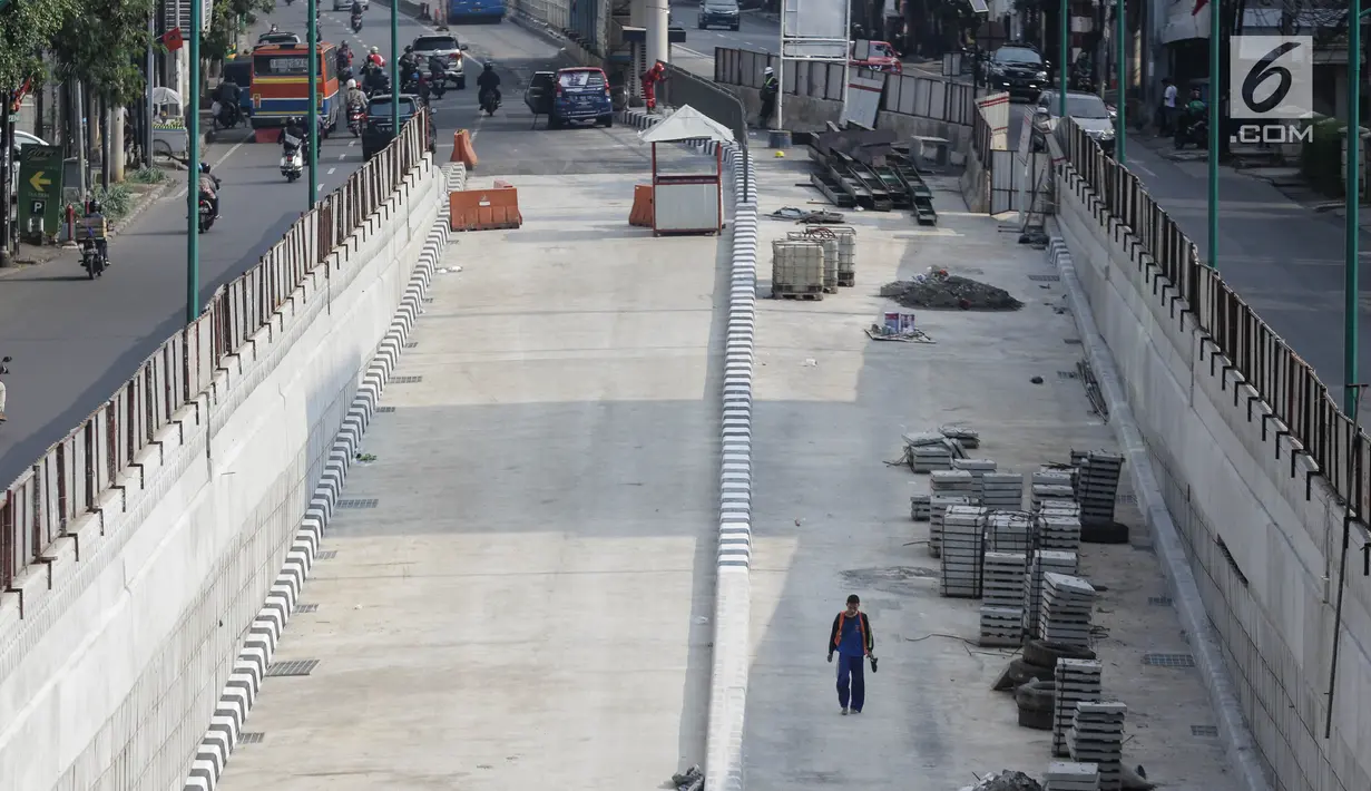 Pekerja terlihat berjalan di proyek pembangunan underpass Mampang Prapatan-Kuningan, Jakarta, Minggu (18/3). Pada dinding underpass Mampang itu nantinya ada ornamen ukiran khas dengan budaya Betawi yang cukup menarik. (Liputan6.com/Faizal Fanani)