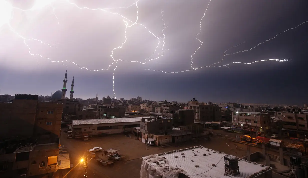 Kilatan petir terlihat saat hujan lebat di atas kota Rafah di Jalur Gaza selatan, Palestina, Kamis (16/1/2020). (AFP/Said Khatib)