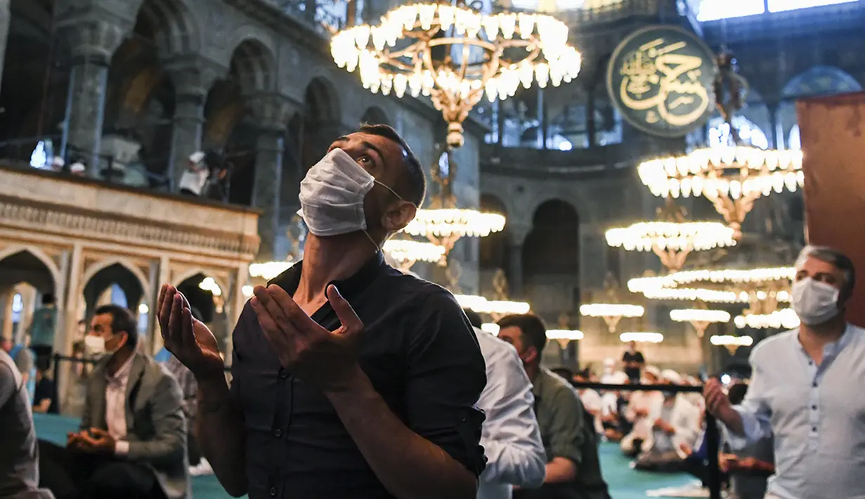Jemaah mengenakan masker dan menerapkan jaga jarak untuk menghindari penularan COVID-19 saat melaksanakan salat Idul Adha di Hagia Sophia, Istanbul, Turki, Jumat (31/7/2020). Ini merupakan salat Idul Adha pertama di Hagia Sophia setelah dialihfungsikan dari museum menjadi masjid. (Pool via AP)