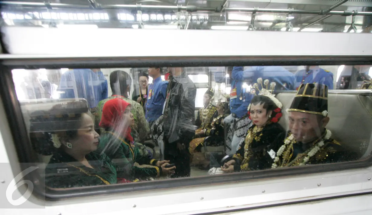 Sejumlah pasangan pengantin duduk di dalam gerbong kereta Prameks jurusan Jogja-Solo selama acara nikah massal di Stasiun Tugu Yogyakarta, Selasa (6/9). Konsep menikah bersama di kereta merupakan pertama kali di Indonesia. (Liputan6.com/Boy Harjanto)