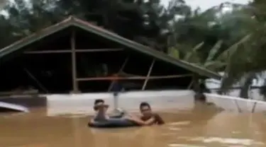 Amukan banjir yang kian parah hingga sekitar 4 meter membuat atap-atap rumah saja yang tersisa.