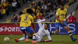 Penyerang Real Madrid, Cristiano Ronaldo, terjatuh akibat berebut bola dengan gelandang Las Palmas, Mauricio Lemos. Sementara bagi Las Palmas kekalahan ini membuat mereka turun ke peringkat 15. (Reuters/Juan Medina)