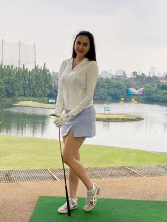 Main golf, Aura Kasih tampil stylish mengenakan jaket olahraga berwarna putih dipadukan mini skirt warna lilac dan sneakers warna abu-abu. (Instagram/aurakasih)..