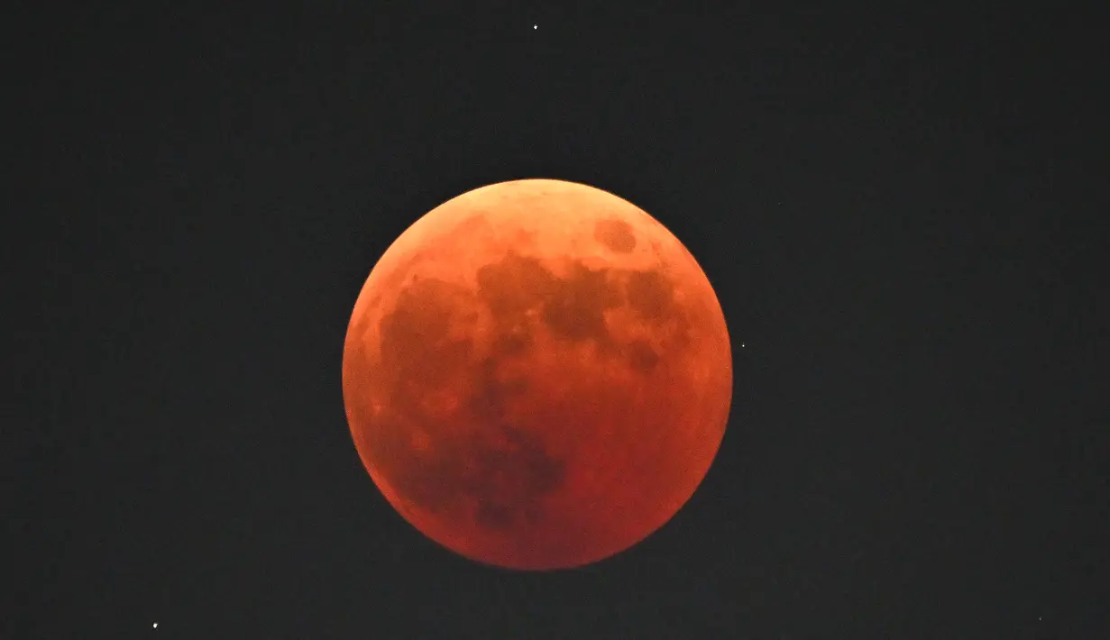 Blood moon terlihat saat gerhana bulan total di Goyang, barat laut Seoul, pada 8 November 2022. Fenomena gerhana bulan total terjadi pada 8 November 2022 di berbagai negara. (AFP/Jung Yeon-Je)