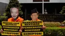 Massa memakai topeng terpidana korupsi Anggodo Widjojo di depan kantor Kemenkum HAM, Jakarta, (22/9/14). (Liputan6.com/Johan Tallo)
