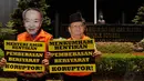 Massa memakai topeng terpidana korupsi Anggodo Widjojo di depan kantor Kemenkum HAM, Jakarta, (22/9/14). (Liputan6.com/Johan Tallo)