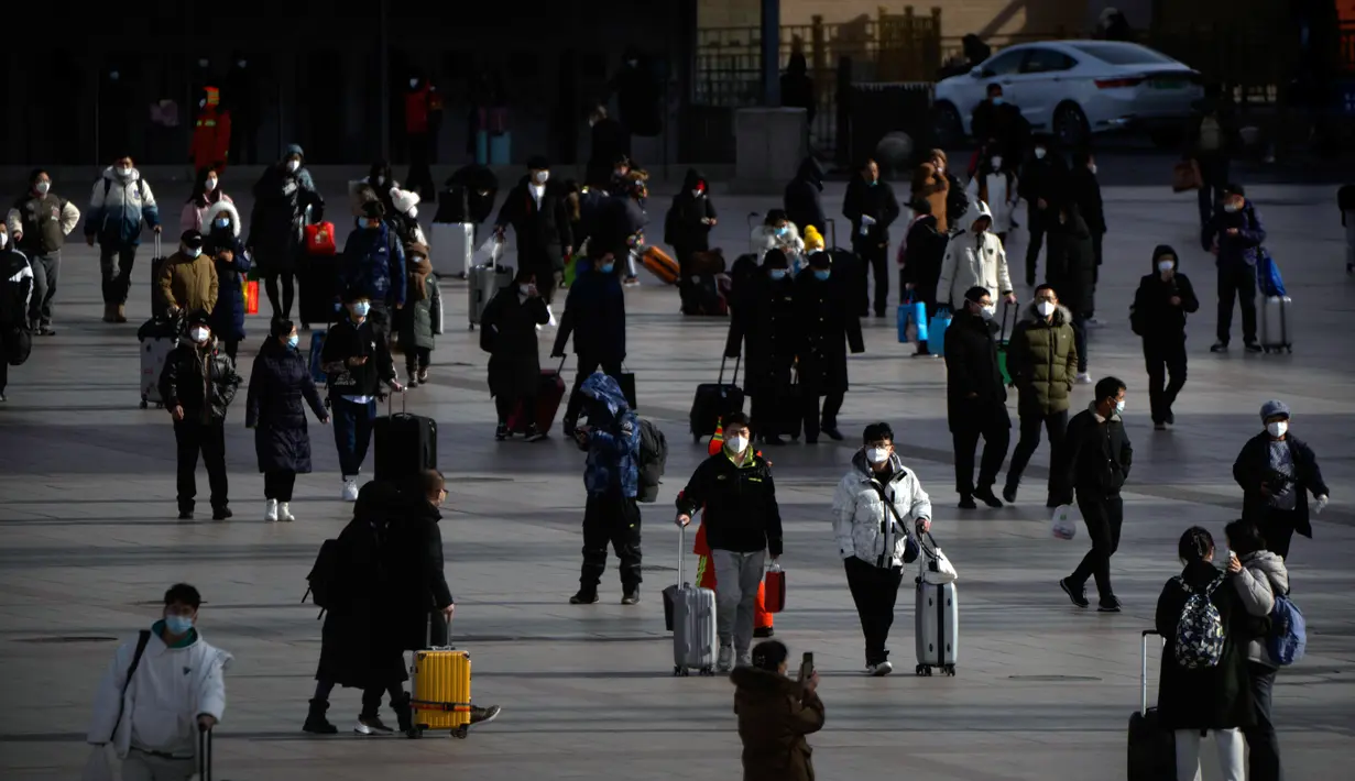 Suasana saat para pemudik yang memakai masker berjalan menuju pintu masuk Stasiun Kereta Api Beijing di Beijing, China, Sabtu (14/1/2023). Jutaan warga China diperkirakan akan melakukan perjalanan selama periode liburan Tahun Baru Imlek tahun ini. (AP Photo/Mark Schiefelbein)