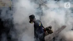 Petugas melakukan pengasapan atau fogging di kawasan perumahan Jalan Delima Raya, Jakarta Barat, Senin (25/10/2021). Pemyemprotan guna membasmi nyamuk Aedes aegypti yang menyebabkan penyakit demam berdarah (DBD) saat musim hujan di kawasan pemukiman warga. (Liputan6.com/Johan Tallo)