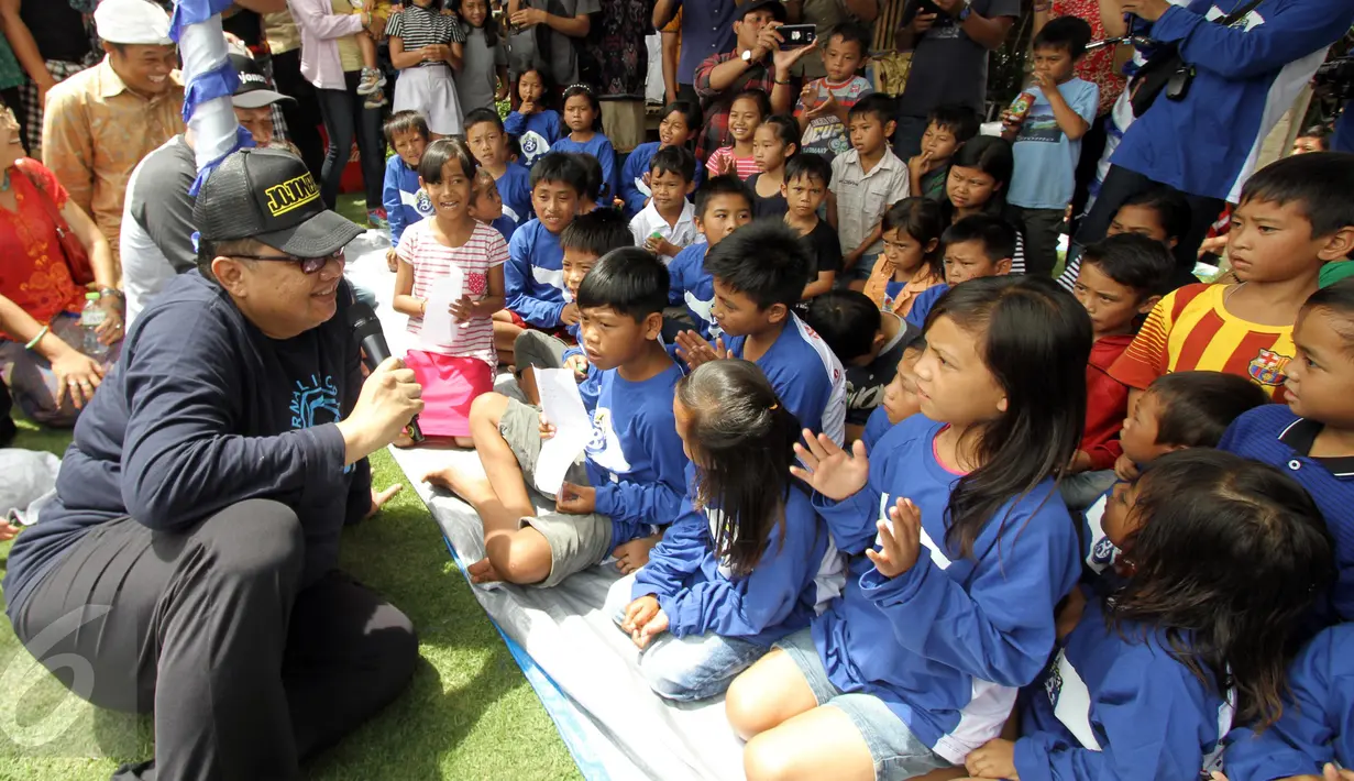 Menteri Koperasi dan UKM Anak Agung Gede Ngurah Puspayoga (kiri) berbincang dengan sejumlah anak saat menghadiri HUT-3 Jurnalis Joran Indonesia (Jojoners) yang mengusung Tema 'Tri Hita Karana', Bali, Jumat (27/1). (Liputan6.com/Angga Yuniar)