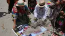 Dukun Peru meletakkan pasir ke atas poster bergambar Capres AS dari Partai Republik, Donald Trump, saat dukun Peru melakukan ritual prediksi menjelang pemilihan presiden AS, di Lima, Peru, Senin (7/11). (REUTERS/Mariana Bazo)