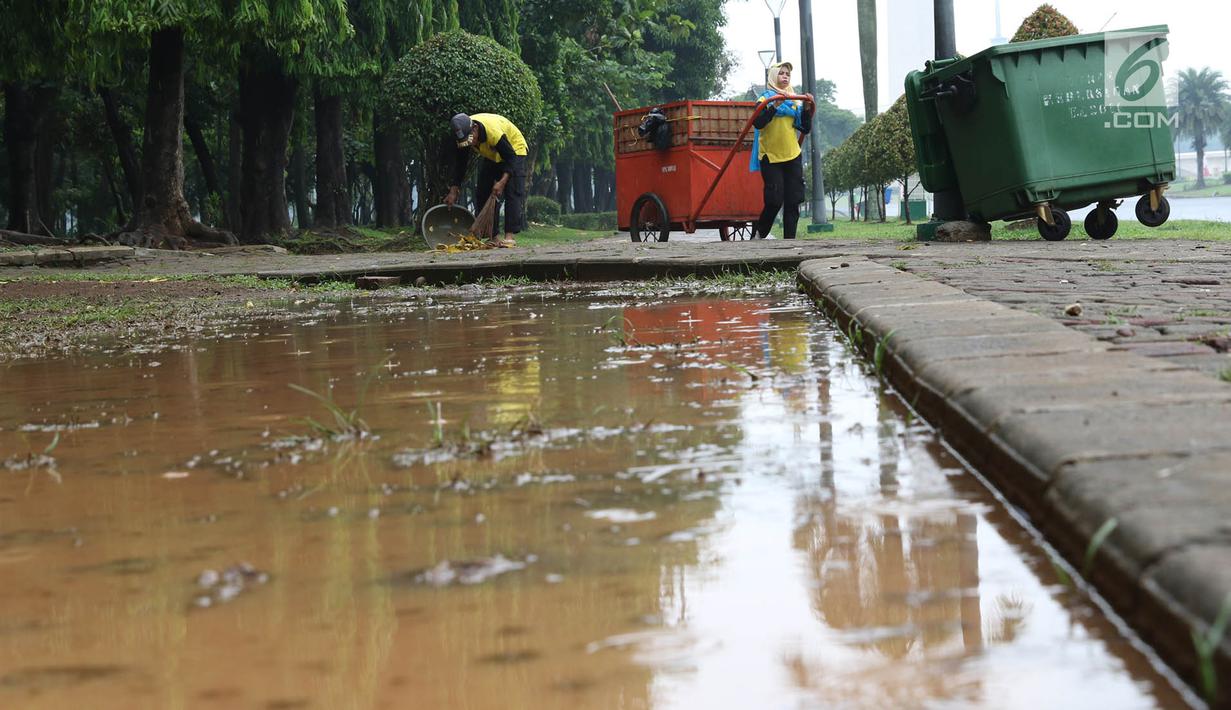 Petugas membersihkan sampah di kawasan Monas, Jakarta, Senin (3/11). Kesigapan petugas kebersihan pasca reuni 212 membuat kawasan tersebut kembali bersih meskipun sehari sebelumnya dipenuhi ratusan ribu orang. (Liputan6.com/Immanuel Antonius)
