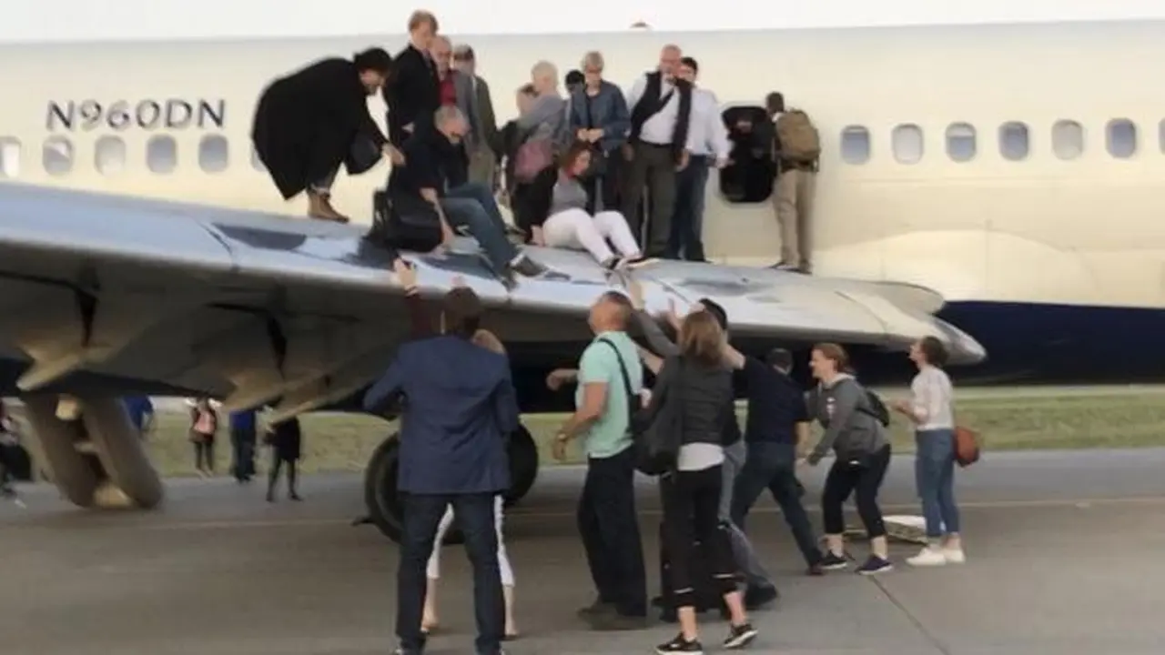 Penumpang Delta Air Lines turun pesawat lewat jendela dan sayap di Bandara Internasional Denver, Colorado, AS. (AP)