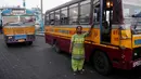 Pratima Poddar berpose di samping bus saat menunggu penumpang di Kolkata, India (8/3). Pratima Poddar 42 tahun merupakan satu-satunya sopir bus umum perempuan di Kolkata. (AFP Photo/Dibyangshu Sarkar)