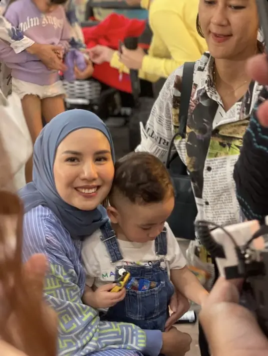 Tya Ariestya hadir mengenakan dress motif bergaris bernuansa biru yang diserasikan dengan kerudungnya. [@dimas_baam]