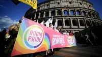 Para peserta memegang spanduk saat mengikuti Pride March tahunan di Roma, pada 11 Juni 2022. (Dok: Filippo MONTEFORTE / AFP)