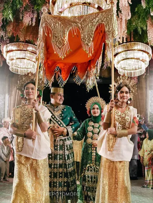 Sementara itu, Andi mengenakan atasan hijau dipadukan dengan sash dan sarung yang serasi dengan pengantin perempuan.  [@thepotomoto]