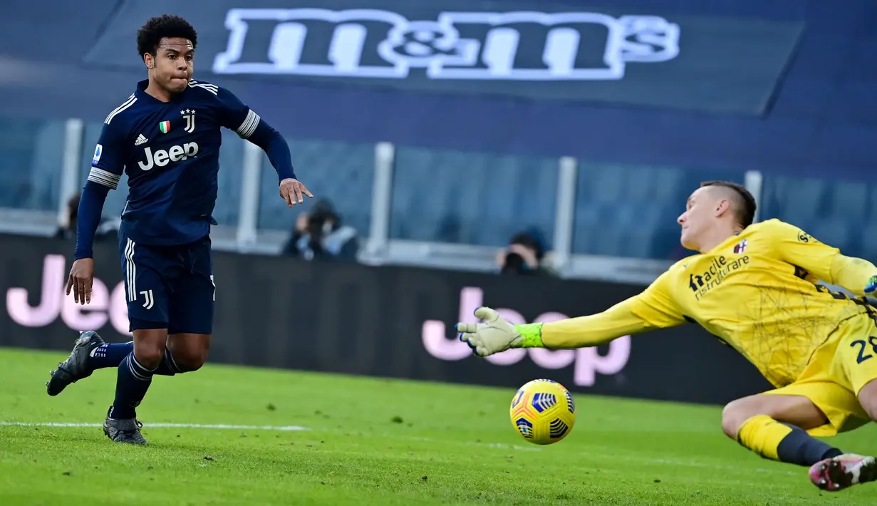 Pemain Juventus, Weston McKennie (kiri) berusaha mengoceh penjaga gawang Bologna, Lukasz Skorupski dalam laga lanjutan Liga Italia di Stadion Allianz, Turin, Minggu (24/1/2021). (Foto: AFP/Miguel Medina)