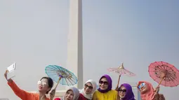 Sejumlah wanita berswafoto mengenakan baju kebaya mengikuti hari Gerakan Nasional kembali ke busana identitas Indonesia di Jakarta, Selasa (2/7/2019). Gerakan ini dinamakan sebagai Selasa Berkebaya untuk mengajak anak-anak muda tetap menjaga kelestarian busana kebaya. (Liputan6.com/Faizal Fanani)