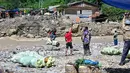 Hingga awal Januari 2026, warga Kecamatan Ketol di Aceh Tengah belum bisa menikmati akses jalan yang layak. Tampak dalam foto, warga menggunakan tali untuk menyeberangi sungai setelah banjir bandang yang menghancurkan desa-desa di sekitarnya di Ketol, provinsi Aceh, pada Selasa 6 Januari 2026. (CHAIDEER MAHYUDDIN/AFP)