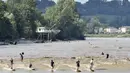 Suasana di Sungai Dordogne, Saint-Pardon, Prancis (24/7). Fenomena pasang surut besar yang menyebabkan gelombang arus di Sungai Dordogne ini dimanfaatkan warga dan turis unutk berselancar. (AFP Photo/Georges Gobet)