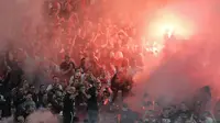 Fans Ajax menyalakan flare saat laga melawan Manchester United fans pada final Liga Europa di Friends Arena, Stockholm, Swedia, (24/5/2017). Manchester United menang 2-0. (AP/Michael Sohn)