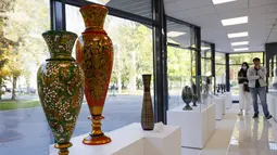 Orang-orang yang memakai masker mengunjungi pameran kesenian rakyat tradisional Rusia di Moskow, Rusia, 4 Oktober 2020. Lebih dari 1.000 karya seni tradisional Rusia buatan produsen kerajinan terkemuka dipamerkan di acara tersebut. (Xinhua/Alexander Zemlianichenko Jr)