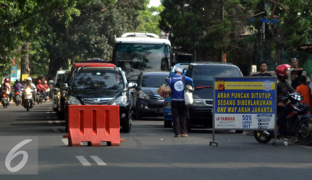 Polisi melakukan rekayasa lalu lintas dengan melakukan sistem buka tutup jalan untuk mengurai kemacetan di kawasan Puncak, Bogor, Jawa Barat. (Liputan6.com/Johan Tallo)