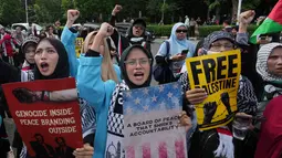Dalam aksinya, massa membawa spanduk bertuliskan penolakan dan mendesak pemerintah Indonesia untuk menarik diri dari keanggotaan badan tersebut. Tampak dalam foto, aktivis Muslim memegang poster dan meneriakkan slogan-slogan selama unjuk rasa dukungan untuk warga Palestina di Gaza, di depan Kedutaan Besar Amerika Serikat, Jakarta, Jumat 13 Februari 2026. (AP Photo/Achmad Ibrahim)
