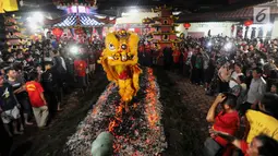 Sebuah barongsai melakukan atraksi Tahwe atau menginjak bara api di Hok Tek Bio Cibinong, Bogor, Sabtu (17/3). Tradisi injak bara tersebut dalam rangka rangkaian Sejit (ulang tahun) Kongco Ho Tek Tjeng Sin atau Dewa Bumi. (Merdeka.com/Arie Basuki)