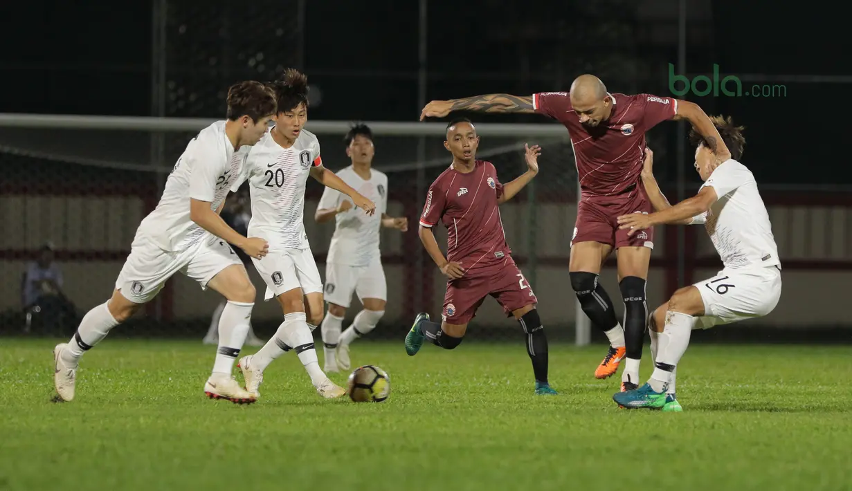 Pemain Persija Jakarta, Ivan Carlos (2kanan) berebut bola dengan pemain Korea Selatan U-23 pada laga uji coba di Stadion PTIK, Jakarta, (21/6/2018). Persija kalah 1-3. (Bola.com/ Nick Hanoatubun)