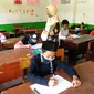 Guru mengawasi murid kelas V saat menjalani ujian Penilaian Akhir Semester (PAS) tahun pelajaran 2020/2021 di Madrasah Ibtidayah (MI) Assu'ada di Pancoran Mas, Depok, Jawa Barat, Selasa (1/12/2020). Ujian dilaksanakan dengan menerapkan protokol kesehatan dalam kelas. (merdeka.com/Arie Basuki)