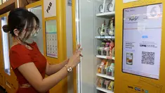 Pengunjung membeli minuman dengan QRIS pada Smart Vending Machine di East Mall Grand Indonesia, Jakarta, Selasa (24/05/2022). Blibli dan Jumpstart berkolaborasi meluncurkan vending machine pertama di Indonesia yang menawarkan ragam produk UMKM terbaik binaan Blibli di bawah GDP Ventures. (Liputan6.com/Fery Pradolo)