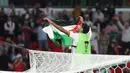 Pemain Yordania, Yazan Al-Naimat membentangkan bendera negaranya saat merayakan kemenangan timnya atas Korea Selatan setelah laga semifnial Piala Asia 2023 di Ahmad Bin Ali Stadium, Doha, Qatar, Selasa (06/02/2024). (AFP/Giuseppe Cacace)