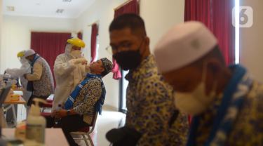 Calon jemaah umrah melakukan tes swab menjelang keberangkatan di Asrama Haji Pondok Gede, Jakarta, Selasa (11/1/2022). Hingga saat ini kurang lebih 1.000 jemaah telah diberangkatkan ke tanah suci Mekkah setelah dua tahun pandemi Covid-19. (merdeka.com/Imam Buhori)