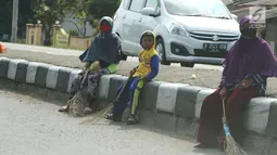 Seorang bocah penyapu koin kali Sewo menunggu di pinggir jalan, Subang, Jawa Barat, Sabtu (7/1). Selain bertambah banyak, kini warga yang mangkal juga dari berbagai kalangan usia, mulai anak-anak hingga dewasa. (Liputan6.com/Helmi Afandi)