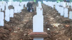 Keluarga berdoa depan pusara makam korban Covid-19 di TPU Srengseng Sawah 2, Jakarta Selatan, Jumat (19/3/2021). Seminggu terakhir intensitas pemakaman korban Covid-19 menurun drastis sebesar rata-rata 20 jenazah/minggu dibandingkan sebelumnya rata-rata 35 jenazah/minggu. (merdeka.com/Arie Basuki)