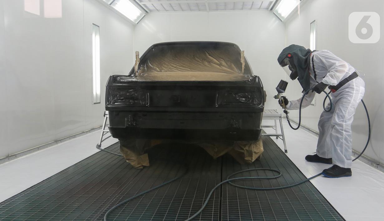 Teknisi mengecat mobil di sela-sela pembukaan BMW Ultima, di Tangerang Selatan, Rabu (16/03/2022). BMW Approved Bodyshop pertama di Indonesia menghadirkan BMW Service Centre dengan konsep sustainability mulai dari penggunaan teknologi dan bahan ramah lingkungan. (Liputan6.com/Fery Pradolo) 